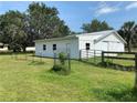 Well-maintained outbuilding with a metal roof, fencing, and mature landscaping at 5760 Howard Creek Rd, Sarasota, FL 34241