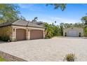 Extensive paver driveway leads to a three-car garage and a large detached garage, perfect for car enthusiasts or extra storage at 5850 Saddle Oak Trl, Sarasota, FL 34241