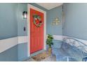 Inviting front porch with a colorful wreath, bench, and charming nautical décor at 5872 Monroe Rd, Venice, FL 34293
