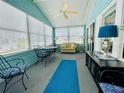 Enclosed porch features neutral carpet, blue accents, and a dining area at 615 S Green Cir, Venice, FL 34285