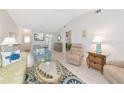 Bright living room featuring tile flooring, vaulted ceilings, and coastal decor at 6796 Gasparilla Pines Blvd # 18, Englewood, FL 34224