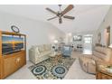 Coastal-themed living room with tile floors, ceiling fan, and a view into the dining area at 6796 Gasparilla Pines Blvd # 18, Englewood, FL 34224