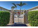 Gated entrance to a shared pool and courtyard, surrounded by lush hedges and decorative concrete walls at 701 Barcelona Ave # 101, Venice, FL 34285