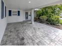 Spacious covered parking area with brick pavers and tropical landscaping at 832 Whitecap Cir # 5, Venice, FL 34285