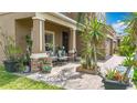 Inviting front porch with decorative potted plants, brick columns, and comfortable seating, adding charm and curb appeal at 9019 39Th Street Cir E, Parrish, FL 34219