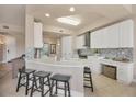 Contemporary kitchen with white cabinets, granite countertops, a breakfast bar, and stylish backsplash at 97 Vivante Blvd # 306, Punta Gorda, FL 33950