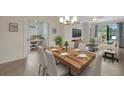 Stylishly decorated dining room with a modern chandelier, view to living room and office at 9823 Haze Dr, Venice, FL 34292