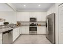 Modern kitchen features stainless steel appliances, white cabinets, and stylish granite countertops at 9823 Haze Dr, Venice, FL 34292