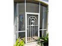Close up of white screened front door with palm tree detail at 10930 Lerwick Cir, Englewood, FL 34223
