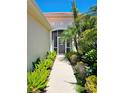Inviting walkway to the front door, surrounded by lush landscaping and tropical plants at 10930 Lerwick Cir, Englewood, FL 34223