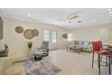 Bright living room boasts a ceiling fan, neutral tones, a cozy chair, and easy access to the outdoor patio at 1099 Nokomis S Ave, Venice, FL 34285