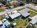 An aerial side view of a blue single-story home, garage, boats, and spacious yard at 1103 Lucille Ave, Nokomis, FL 34275