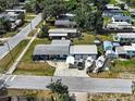An aerial view shows a blue single-story home with a long driveway, garage, boats parked near neighborhood at 1103 Lucille Ave, Nokomis, FL 34275