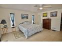 Serene main bedroom with neutral walls, tile flooring, and two windows providing ample light at 1203 Hudson Rd, Venice, FL 34293