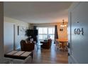 Bright living room with two leather chairs, dining table and chairs, and access to a balcony at 1255 Tarpon Center Dr # 604, Venice, FL 34285