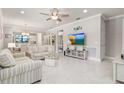 Bright living room with tile floors, neutral paint, and a view into the kitchen and dining areas at 13829 Alafaya St, Venice, FL 34293