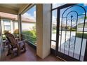 Relaxing side porch with comfortable chairs, screened walls and view of the lush landscaping at 1438 Maseno Dr, Venice, FL 34292