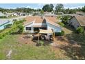 Aerial view showcases home's backyard patio with awning and exterior, with a view of the surrounding neighborhood at 1439 Strada D Argento, Venice, FL 34292