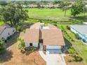 Inviting home featuring a well-maintained lawn, and a golf course view with mature trees in the background at 1439 Strada D Argento, Venice, FL 34292