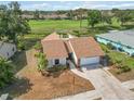 Inviting home featuring a well-maintained lawn, and a golf course view with mature trees in the background at 1439 Strada D Argento, Venice, FL 34292