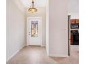 Welcoming entryway with decorative door, chandelier, and neutral tile flooring at 1493 Maseno Dr, Venice, FL 34292