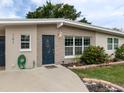 Close-up of a home showcasing a blue front door, a stone accent wall, and manicured landscaping at 161 Suntan Ave, Sarasota, FL 34237