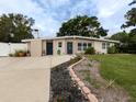 Inviting home exterior featuring a manicured lawn, stone accents, and a long driveway at 161 Suntan Ave, Sarasota, FL 34237