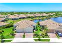 Scenic lakefront home with a tile roof and verdant landscaping at 21649 Avon Park Ct, Venice, FL 34293