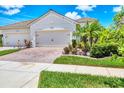 Close-up of a home showcasing a three-car garage and manicured lawn at 21649 Avon Park Ct, Venice, FL 34293