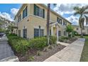 Two-story townhouse with lush landscaping, sidewalk, and tropical palm trees at 233 Cape Harbour Loop # 107, Bradenton, FL 34212