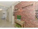 Hallway features faux brick accent wall, wine racks, console table and view of the living area at 241 Marcheno Way, Nokomis, FL 34275