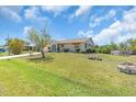 Single-story house featuring an attached garage, mature landscaping, and a well-kept lawn at 2618 Titania Rd, Englewood, FL 34224