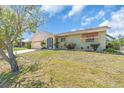 Single-story home featuring an attached garage, mature landscaping, and a well-kept lawn at 2618 Titania Rd, Englewood, FL 34224