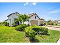 Beautiful two-car garage home with brick driveway and lush landscaping at 27467 Janzen Ct, Englewood, FL 34223