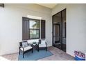 Inviting patio featuring comfortable chairs, a small table, and a stylish rug perfect for relaxing at 27467 Janzen Ct, Englewood, FL 34223