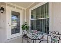 Cozy porch area with decorative table, chairs, and a patterned-glass door at 318 Venice East Blvd, Venice, FL 34293