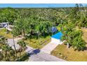 Eye-catching aerial view of a quaint home with a striking blue roof nestled among lush greenery at 352 Glenwood Ave, Osprey, FL 34229