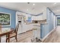 Bright kitchen featuring white cabinets, granite countertops, a breakfast bar, and hardwood floors at 352 Glenwood Ave, Osprey, FL 34229