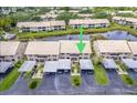 Aerial view of condo complex featuring lush landscaping, lake views, and convenient parking at 410 Mission E Trl # B, Venice, FL 34285