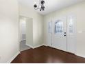 Traditional foyer with hardwood floors features a decorative glass door and chandelier at 4305 Heyward St, North Port, FL 34291