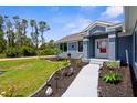 Inviting entryway showcasing a garden with a variety of small plants and gray sidewalk at 4305 Heyward St, North Port, FL 34291