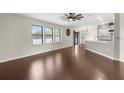 Open-concept living area with hardwood floors, multiple windows, and kitchen access at 4305 Heyward St, North Port, FL 34291