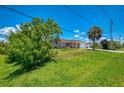 Inviting single-story home with a lush green lawn, enhanced by mature trees and a long driveway at 4321 Shamrock Dr, Venice, FL 34293