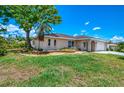 Quaint single-story home featuring a well-manicured lawn, complemented by mature trees and tasteful landscaping at 4321 Shamrock Dr, Venice, FL 34293