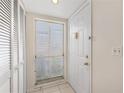 Bright entryway with tile floors, a window with blinds, and a white front door with gold hardware at 458 Cerromar Rd # 382, Venice, FL 34293