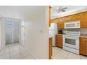 Inviting kitchen featuring white appliances and wood cabinets, seamlessly connecting to the entryway at 458 Cerromar Rd # 382, Venice, FL 34293