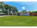 Single Gathering home featuring a lush green lawn, mature trees, and classic landscaping enhancing its curb appeal at 4616 Leeta Ln, Sarasota, FL 34234