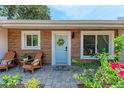 Cozy front porch with chairs and a blue door adorned with a wreath, showcasing an inviting entryway at 4616 Leeta Ln, Sarasota, FL 34234