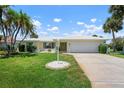 Landscaped front lawn with palms and meticulous shrubs with a 2 car garage at 465 Laurencin Dr, Nokomis, FL 34275