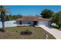 Single-story home showcasing the well-kept lawn, mailbox and a glimpse of the fence at 552 Bellaire Dr, Venice, FL 34293